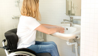 Woman in a wheelchair washing her hands
