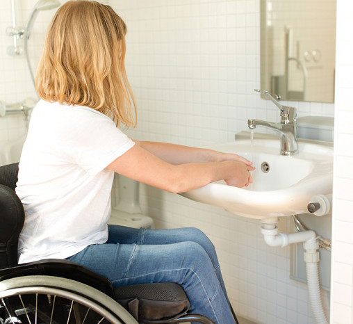 Woman in a wheelchair washing her hands