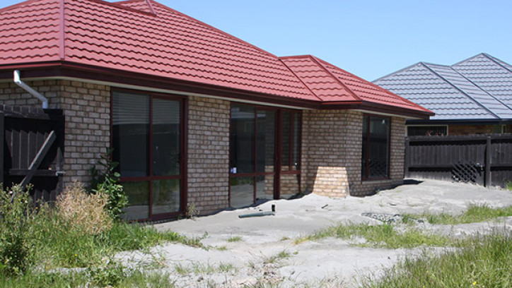 House surround by silt as a result of liquefaction.