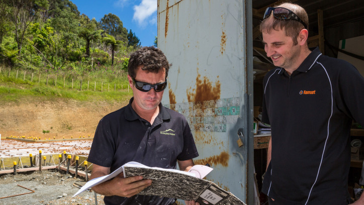 Two builders reviewing paperwork on site