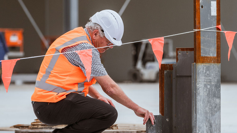 Man in high-vis best inspecting construction
