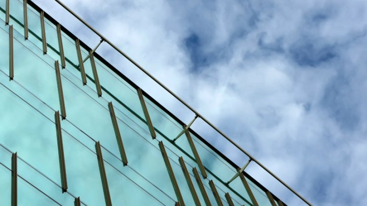 The side of a building reflecting the clouds