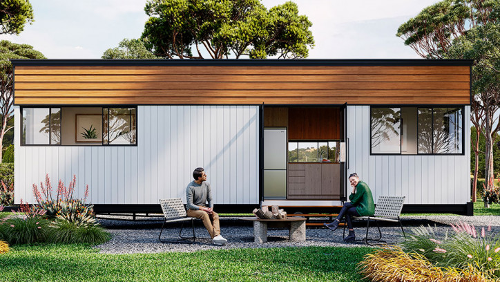 Two people sitting outside a modern tiny house