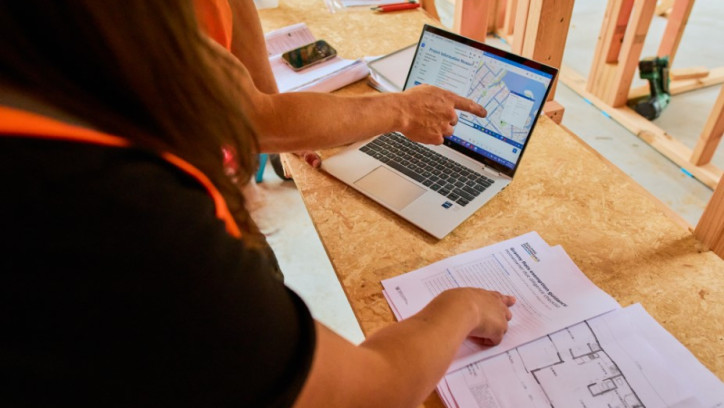 Person pointing to a homeowner due diligence checklist on a construction site