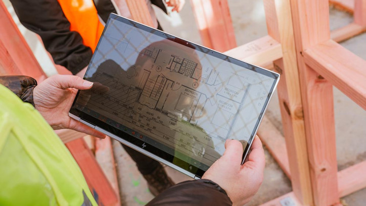 Building inspector looking at plans on a tablet.