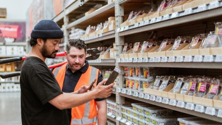Tradesperson and shop assistant discuss a product at building supplies store