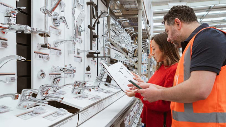 Homeowner and retail employee looking at tapware products in a retail store.